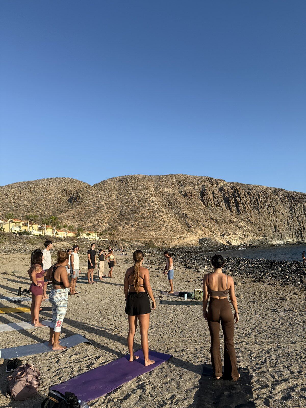 Clase de yoga en la playa con vistas a la montaña
